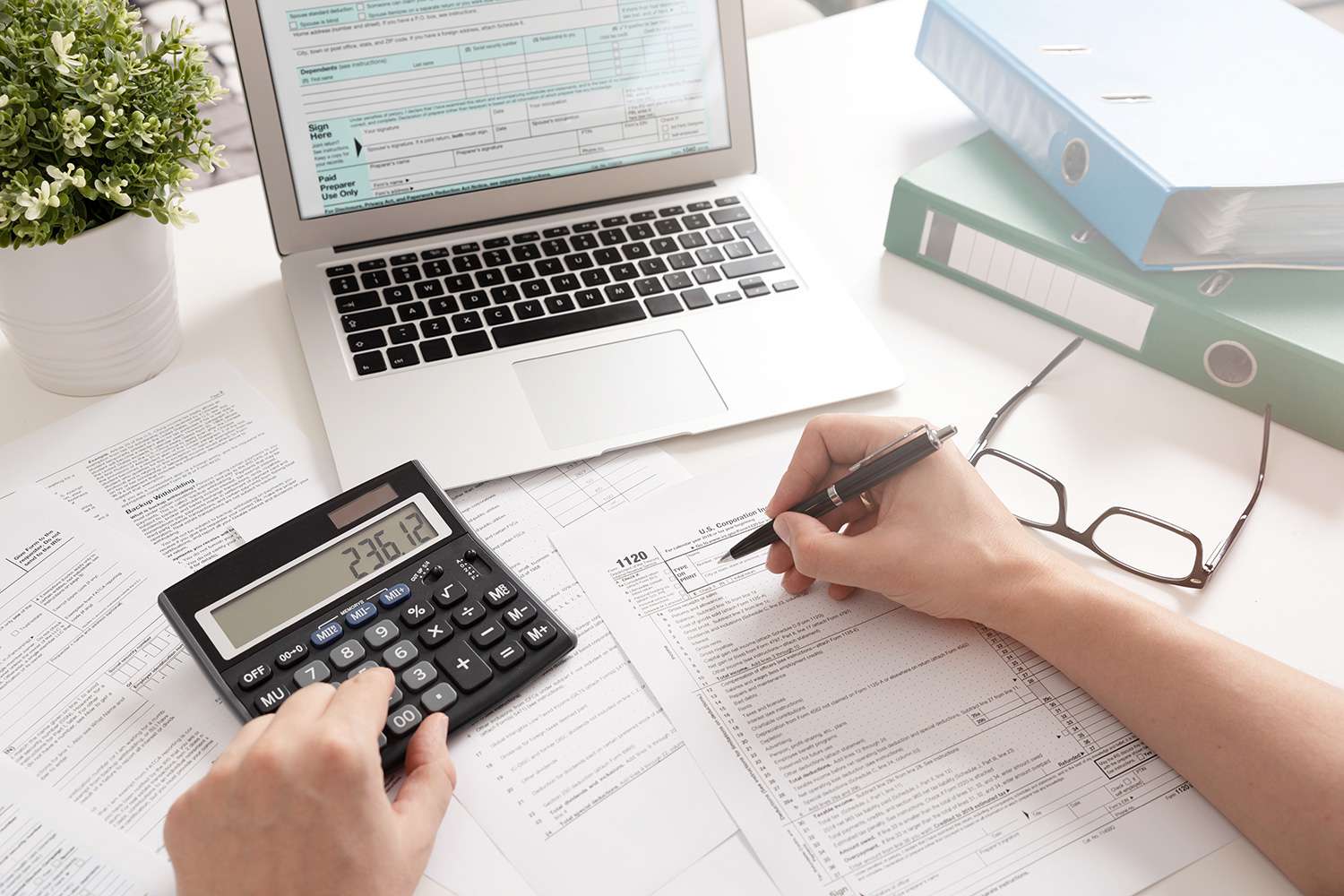 person doing taxes with calculator